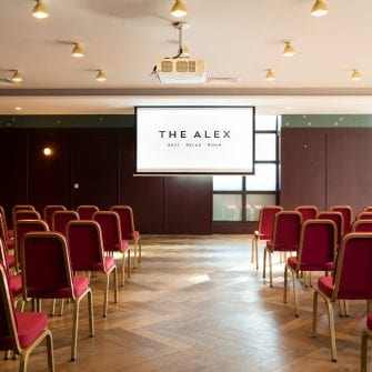 Screen and chairs set up for an event at The Alex Hotel