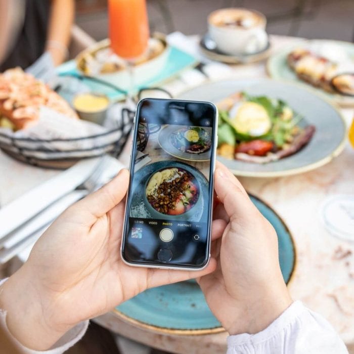 girl taking photo of food at the alex hotel